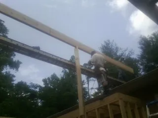 Carpenter setting a ridge beam over a new addition frame — Ice Dam Removal by Roofing Brothers in Lesterville