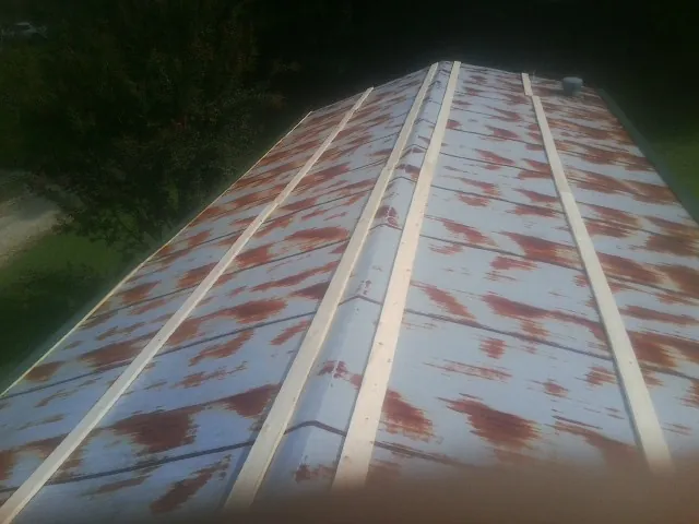 Rusted metal roof panels with new wood purlins before replacement — Storm Damage Roof Repair in Lesterville by Roofing Brothers